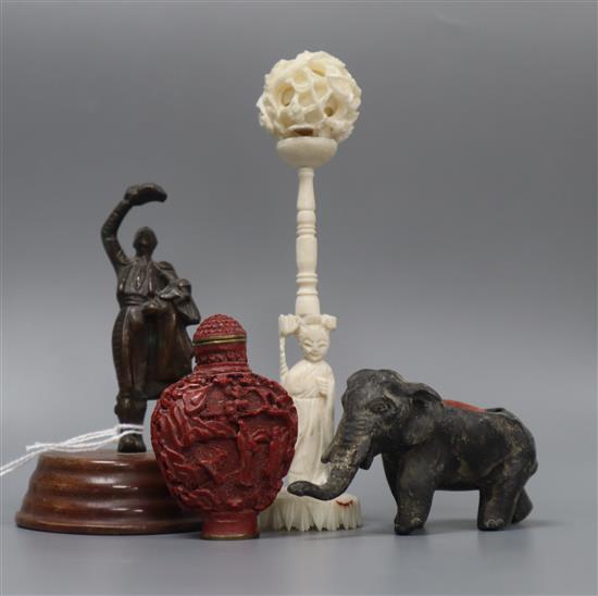 A carved ivory concentric ball on stand, a snuff bottle, an elephant pin cushion and a miniature statue